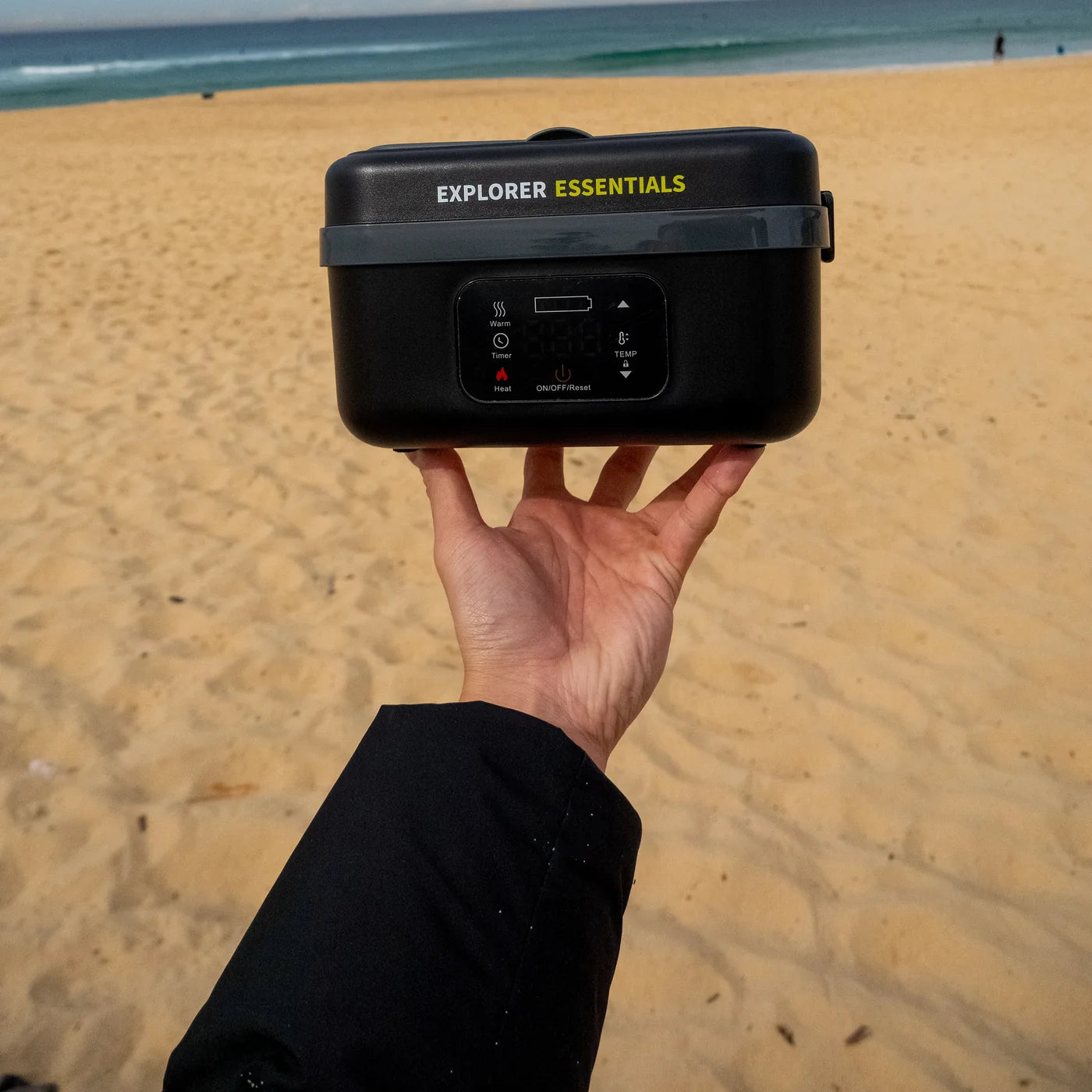 Explorer heated lunchbox held up on the beach